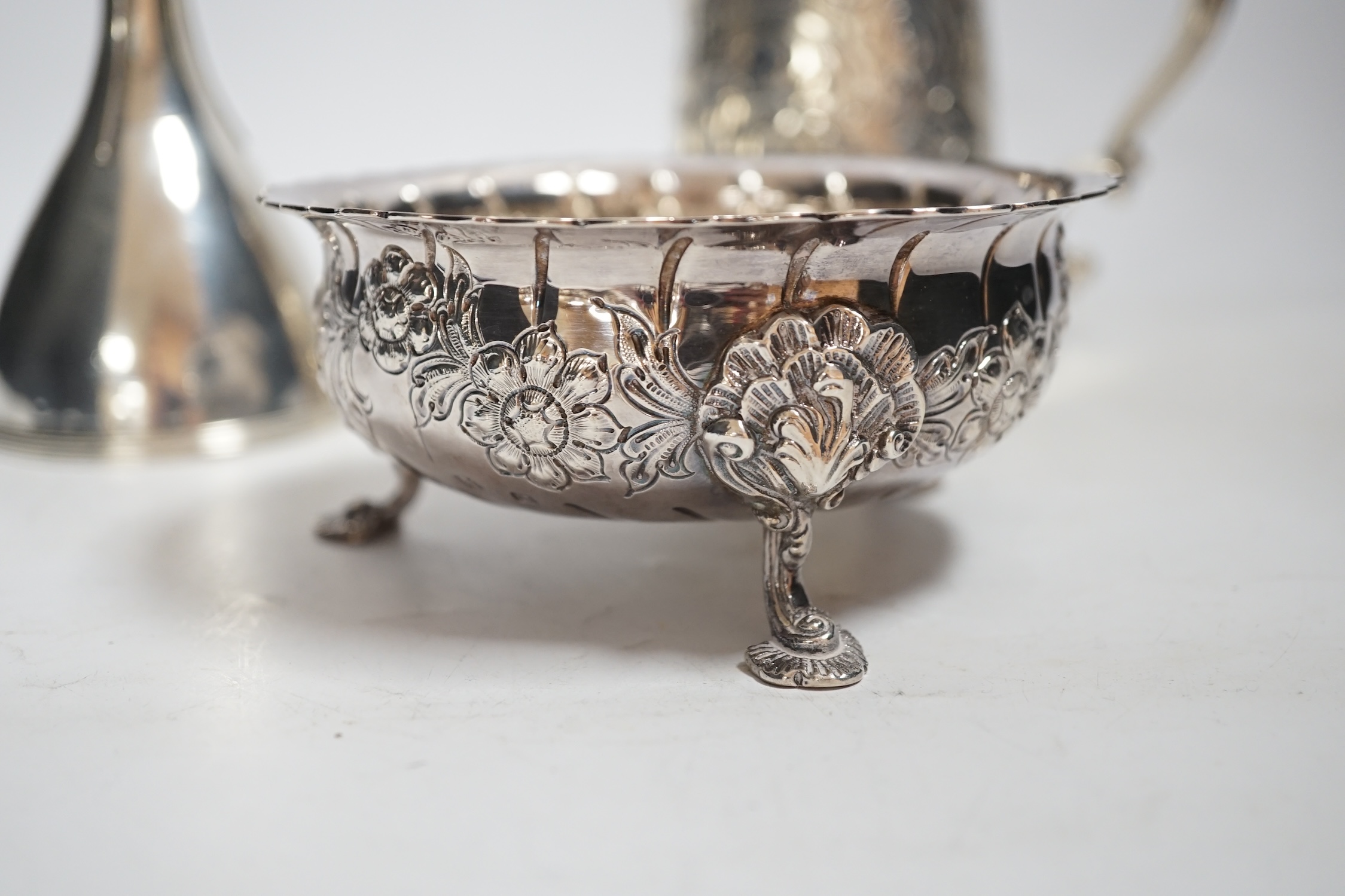 A George III silver mug, with later embossed decoration, London, 1783,11.6cm, together with a George III silver wine funnel and a modern Irish silver sugar bowl, 21.5oz.